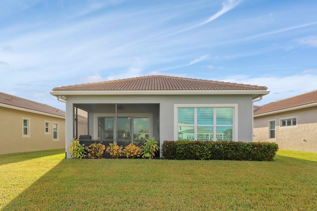 view of side of home featuring a sunroom and a lawn