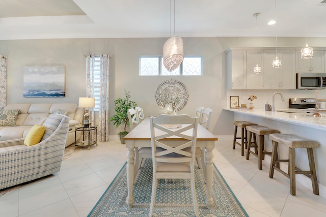 tiled dining room featuring sink