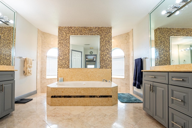 bathroom with vanity, a relaxing tiled tub, and tile walls