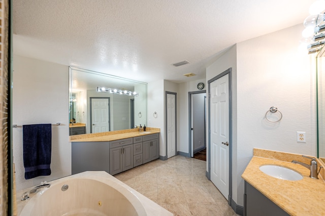 bathroom featuring vanity, a textured ceiling, and a washtub