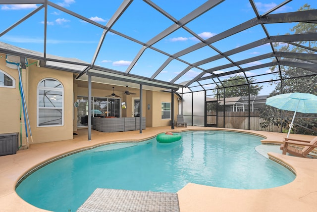 view of pool featuring a patio area, glass enclosure, and ceiling fan