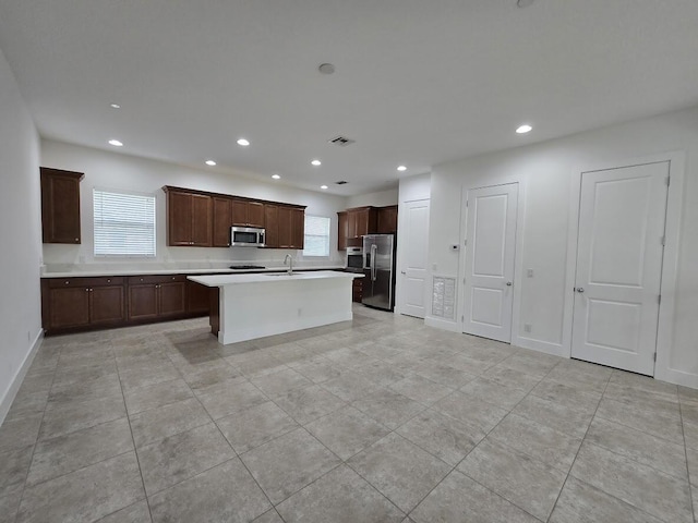 kitchen featuring light countertops, appliances with stainless steel finishes, a sink, and recessed lighting