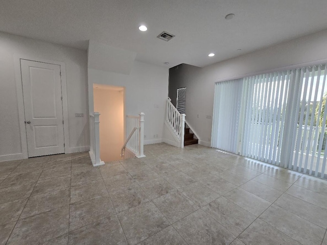 tiled spare room with recessed lighting, visible vents, and baseboards