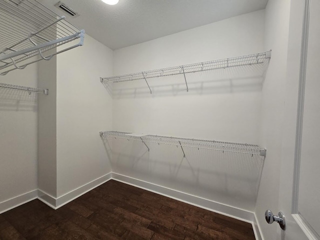 walk in closet with visible vents and wood finished floors