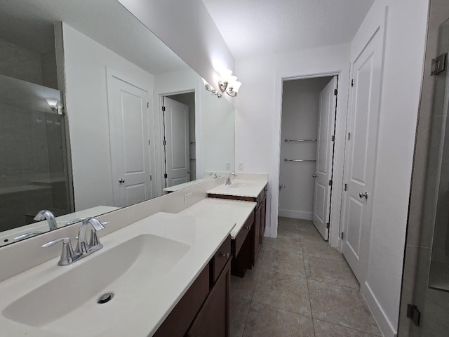 full bathroom featuring double vanity, tile patterned flooring, a sink, and baseboards