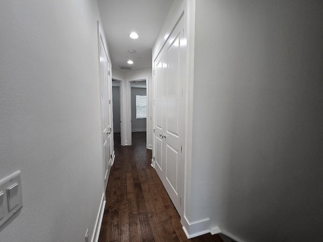 corridor with visible vents, dark wood finished floors, and baseboards