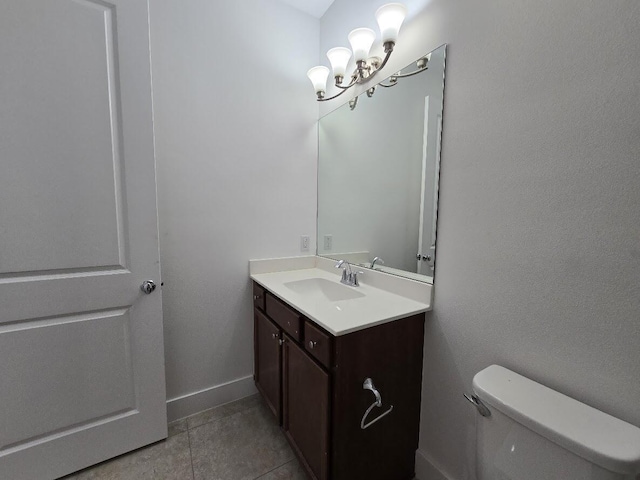 half bathroom with tile patterned flooring, toilet, vanity, baseboards, and an inviting chandelier