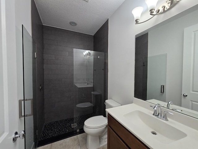 full bathroom with a textured ceiling, toilet, vanity, a shower stall, and tile patterned floors