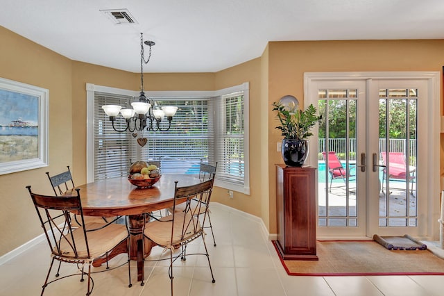 tiled dining area featuring french doors and a notable chandelier