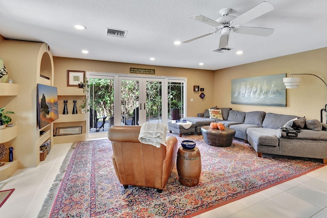 tiled living room with ceiling fan, a textured ceiling, and french doors