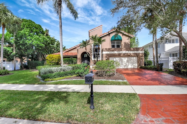 mediterranean / spanish house featuring a front lawn and a garage