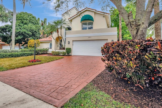 mediterranean / spanish house with a garage and a front yard