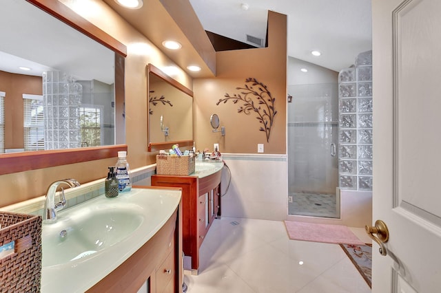 bathroom with tile patterned flooring, vanity, vaulted ceiling, and walk in shower