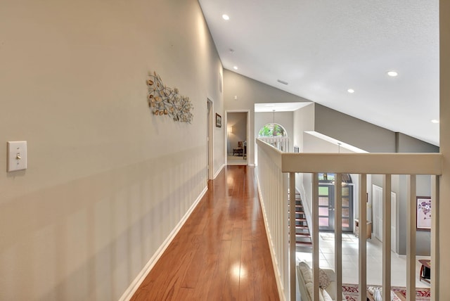 hall featuring hardwood / wood-style flooring and vaulted ceiling