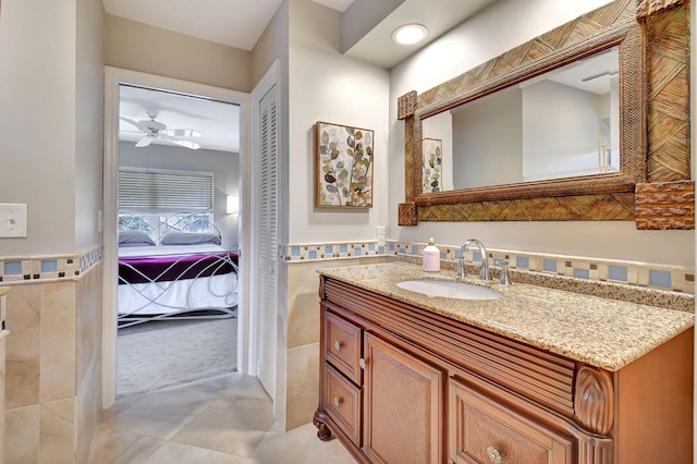 bathroom featuring tile patterned floors, ceiling fan, tile walls, and vanity