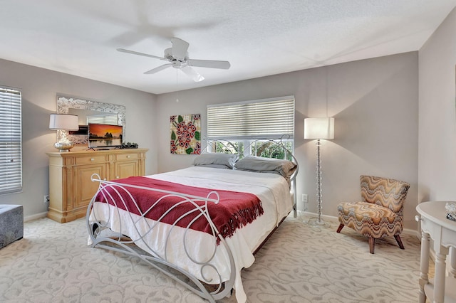 carpeted bedroom with ceiling fan and a textured ceiling