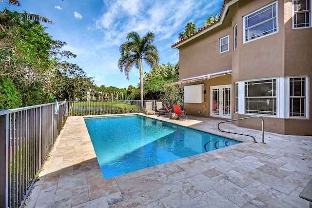 view of swimming pool with french doors and a patio