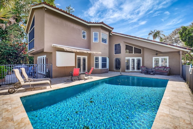 back of house with a fenced in pool, a patio, and french doors