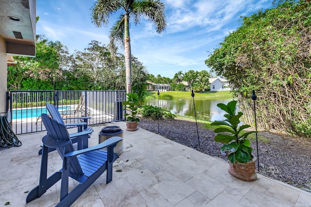 view of patio featuring a water view and a fenced in pool