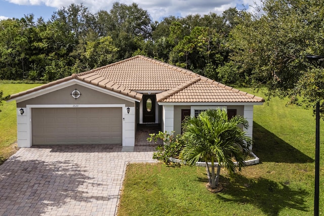 mediterranean / spanish-style home featuring a front lawn and a garage