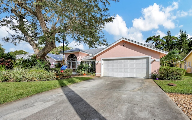 view of front of property with a front yard and a garage