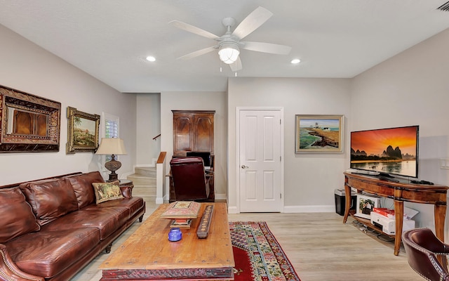 living room with ceiling fan and light hardwood / wood-style flooring