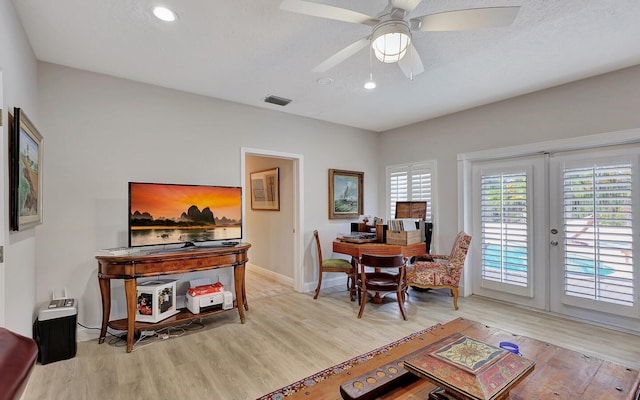 dining area featuring light hardwood / wood-style floors, french doors, a textured ceiling, and ceiling fan