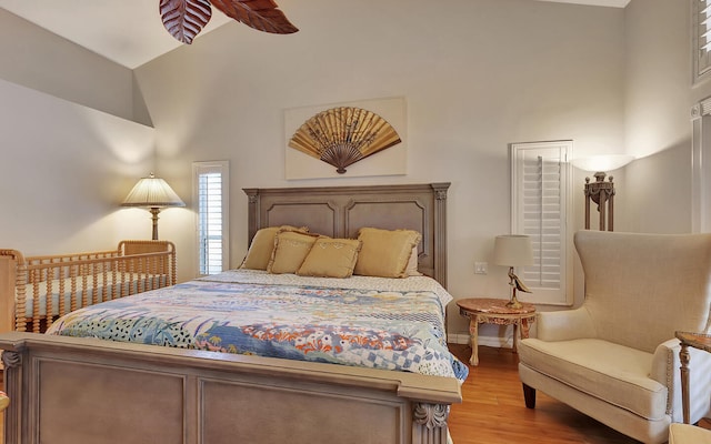 bedroom featuring ceiling fan, high vaulted ceiling, and light wood-type flooring