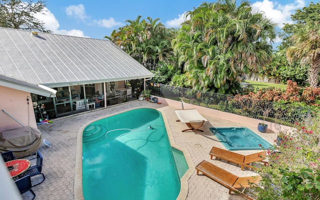 view of swimming pool with a patio area and a sunroom