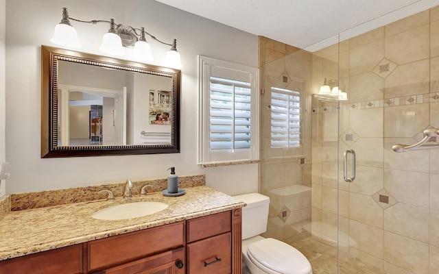 bathroom with toilet, walk in shower, and vanity