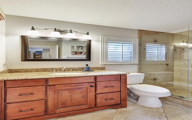 bathroom featuring a shower with door, a textured ceiling, toilet, vanity, and tile patterned floors