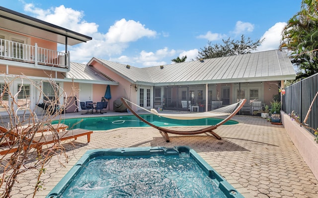 view of swimming pool featuring a patio area and a sunroom