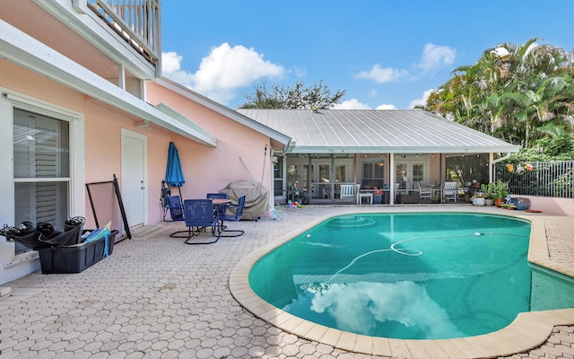 view of swimming pool with a patio and a sunroom