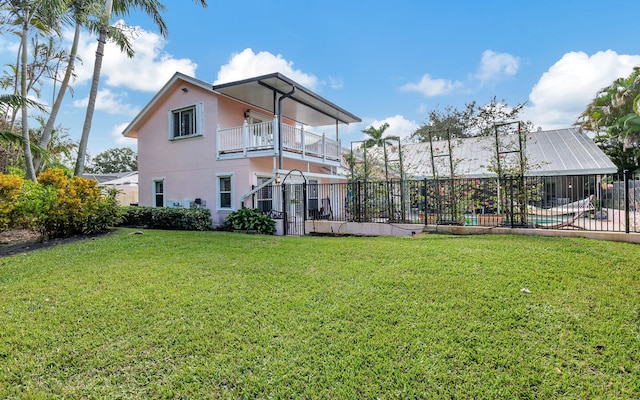 rear view of property featuring a lawn and a balcony