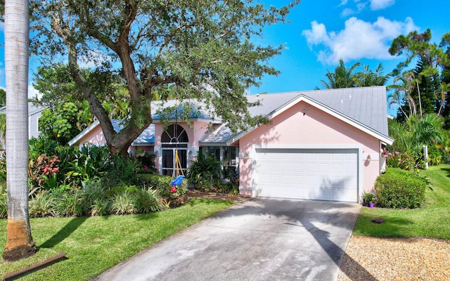 view of front of property featuring a front yard and a garage