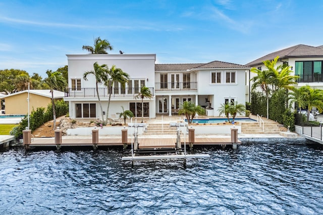 rear view of property with a patio, a water view, and a balcony