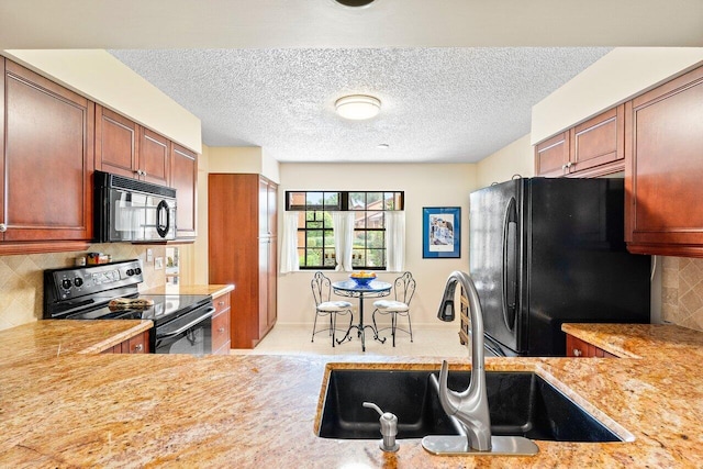 kitchen with a textured ceiling, black appliances, sink, and kitchen peninsula