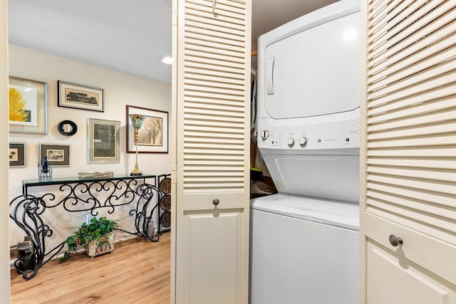 washroom with stacked washer / dryer and light wood-type flooring