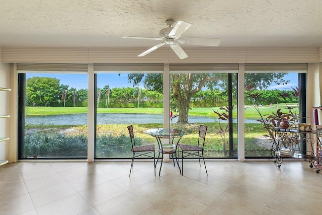 unfurnished sunroom with a water view and ceiling fan