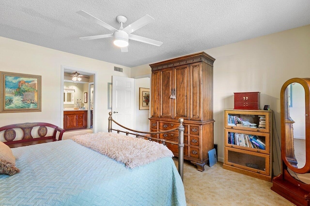 bedroom with connected bathroom, light carpet, a textured ceiling, and ceiling fan