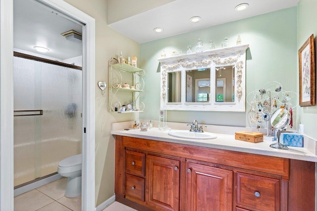 bathroom with vanity, toilet, walk in shower, and tile patterned flooring