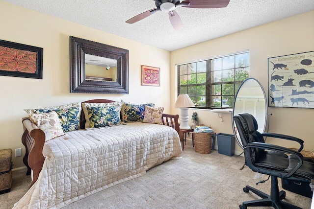 bedroom featuring ceiling fan, a textured ceiling, and light colored carpet