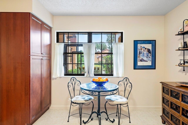 tiled dining space featuring a textured ceiling