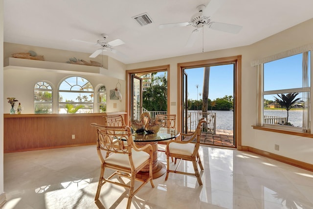 dining space featuring a water view, plenty of natural light, and ceiling fan