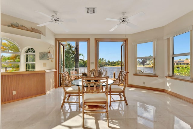 sunroom / solarium with a water view and ceiling fan