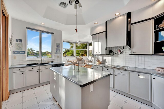 kitchen featuring a kitchen island, ceiling fan, black appliances, and sink