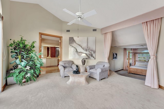 living area featuring ceiling fan, carpet floors, and vaulted ceiling