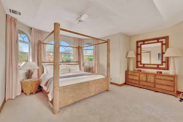 carpeted bedroom featuring multiple windows, ceiling fan, and a textured ceiling