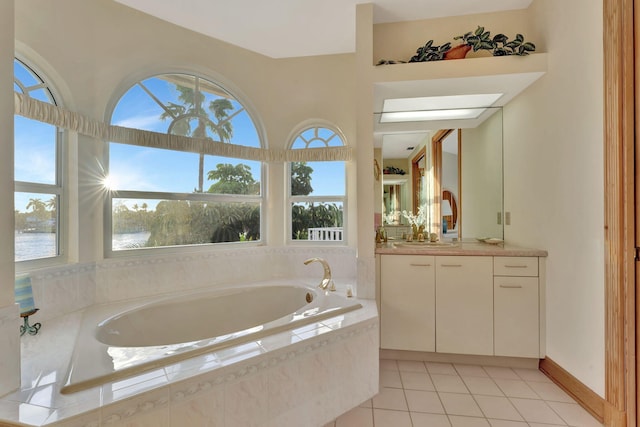 bathroom featuring tile patterned flooring, vanity, a water view, and tiled tub