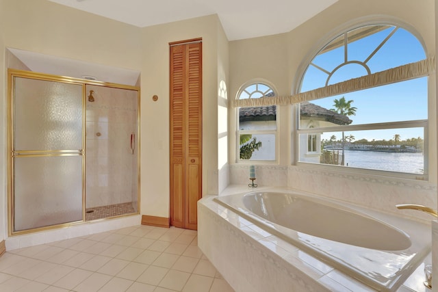 bathroom featuring tile patterned floors, plus walk in shower, and a water view